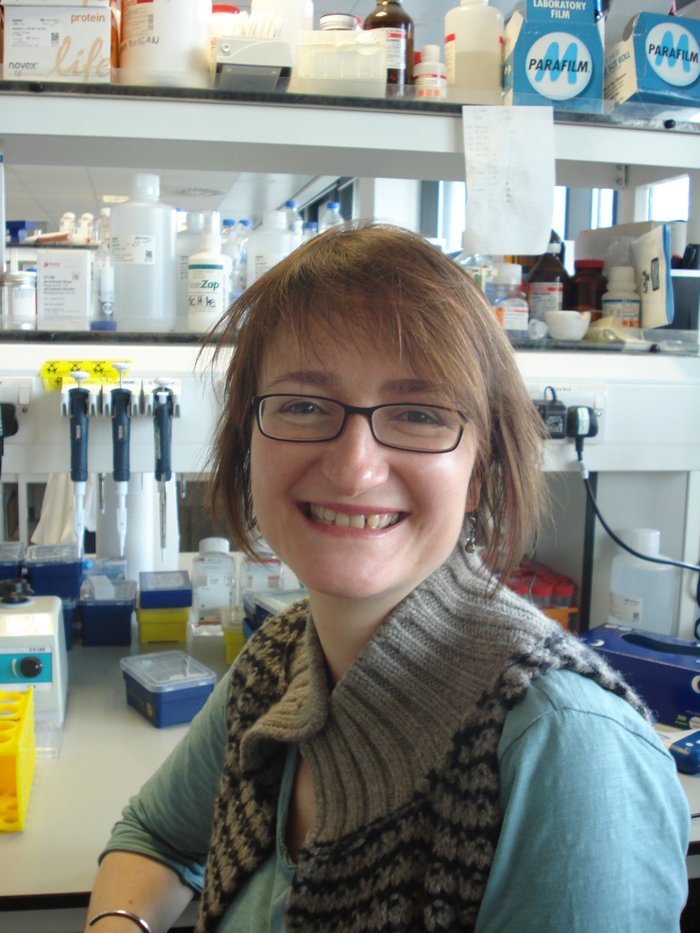 Dr Alison Michie sitting in the lab smiling.