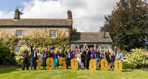 A group of people happy holding up the amount of money raised