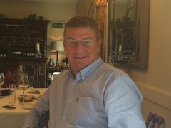 Steve, who lived with myeloproliferative neoplasm (MPN), smiles at the camera whilst sitting at a table in a restaurant.