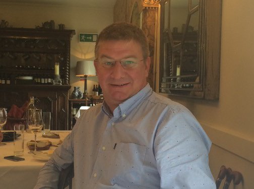 Steve, who lived with myeloproliferative neoplasm (MPN), smiles at the camera whilst sitting at a table in a restaurant.