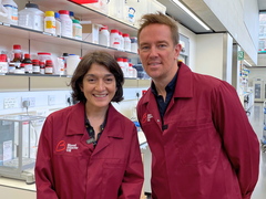 A man and a women in Blood Cancer UK lab coats smiling at the camera