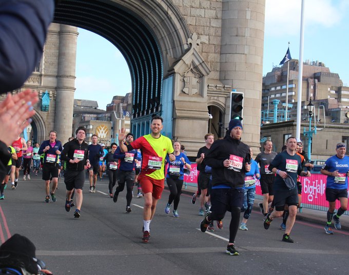 A brightly coloured runner for Blood Cancer UK runs across Tower Bridge at the Vitality Big Half Marathon.