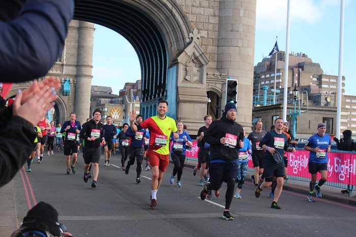 A brightly coloured runner for Blood Cancer UK runs across Tower Bridge at the Vitality Big Half Marathon.