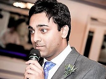 Blood Cancer Trustee, Amir Sethu, making a speech whilst holding a microphone at a wedding.