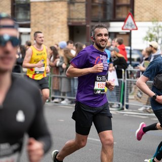 Male Blood Cancer UK runner smiling towards the camera mid run