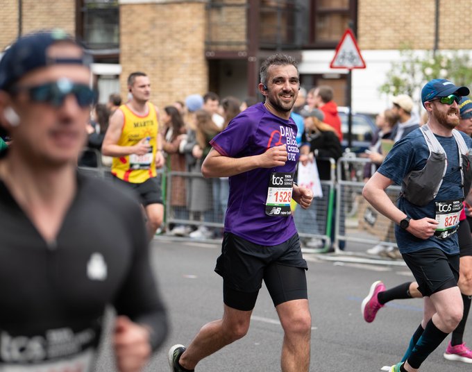 Male Blood Cancer UK runner smiling towards the camera mid run