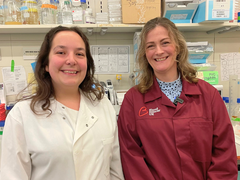 Dr Beth Payne & Dr Alexandra Lubin stood in the lab wearing their lab coats.