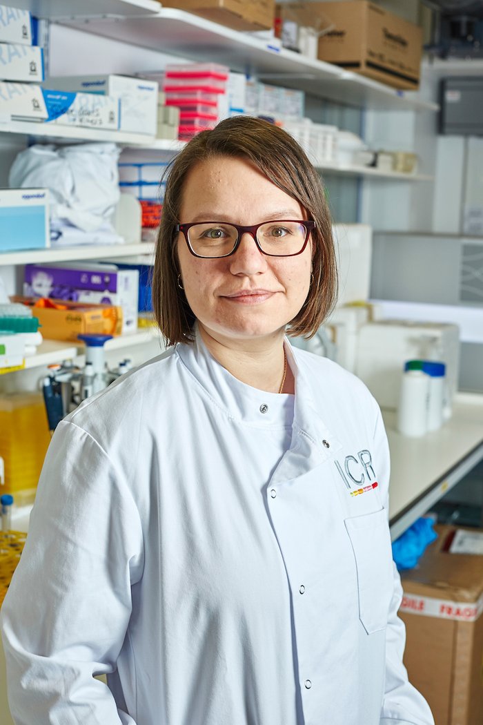 Dr Radzisheuskaya stood in the lab smiling wearing a white lab coat.