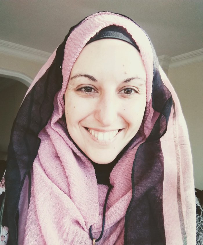 A selfie of a woman (Federica) smiling, wearing a pink and black headscarf