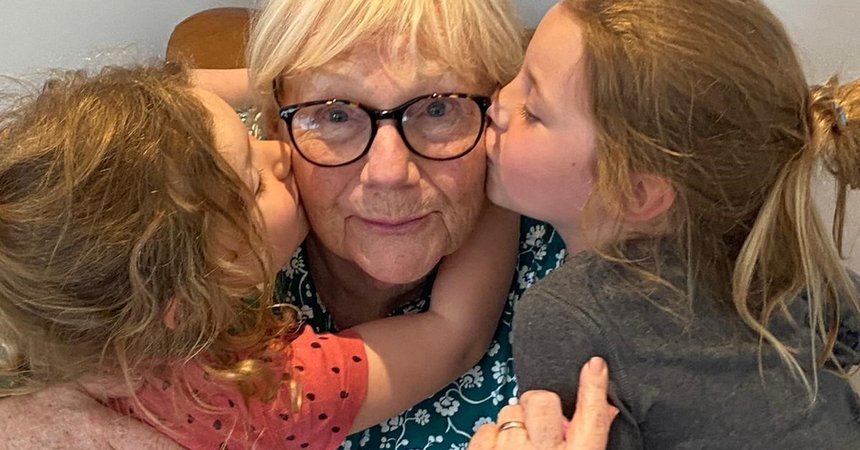 Gail, who's living with essential thrombocythaemia (ET), being hugged by two of her grandchildren.