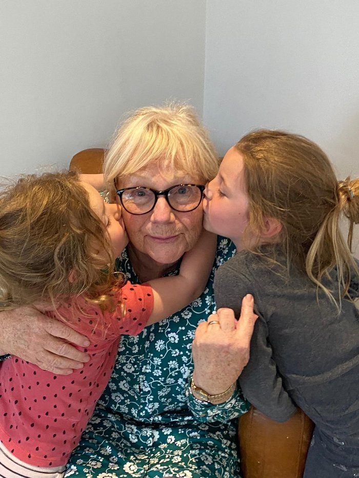 Gail, who's living with essential thrombocythaemia (ET), being hugged by two of her grandchildren.