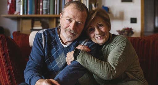 Couple arm in arm, smiling at the camera.