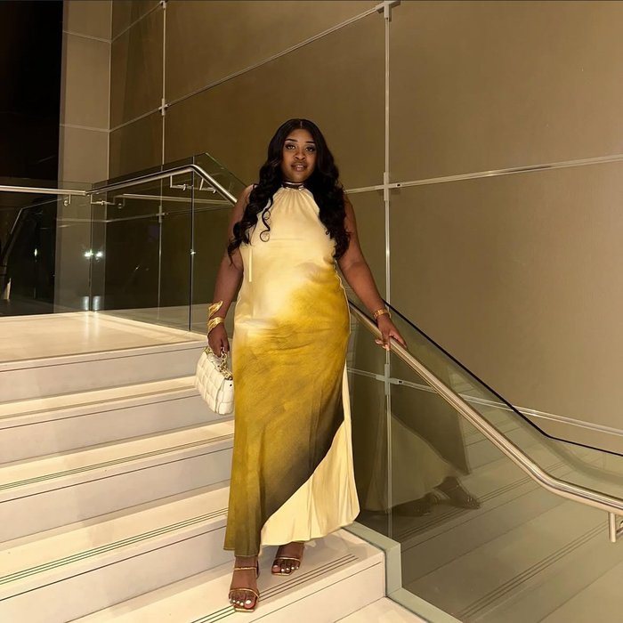 Mphango, who had has treatment for acute myeloid leukaemia (AML), dressed smartly, standing on a staircase.