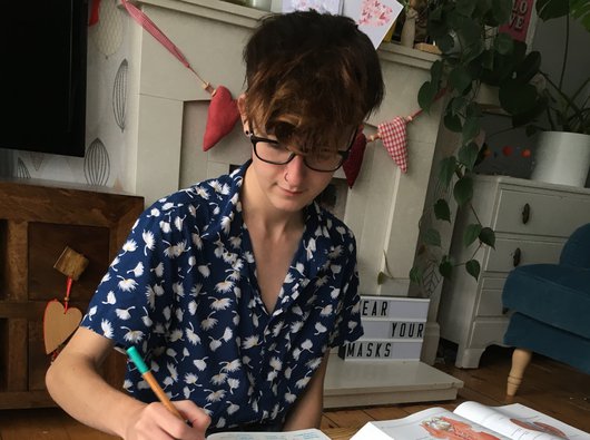 Jamie, who has blood cancer, doing homework in his living room.