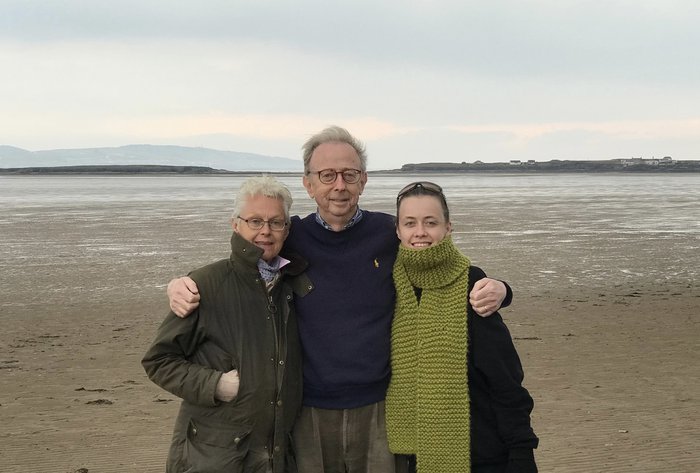 A group shot of Jasmine and her mum and dad on a windswept beach near the Wirral