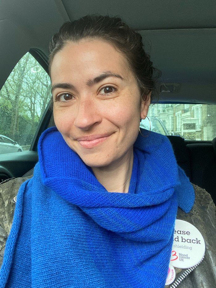 Jess, in her 40s, wearing a blue scarf and Blood Cancer UK shielding badge.