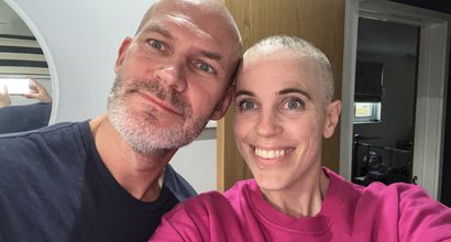 Jess, in remission from diffuse large B-cell lymphoma, smiling at the camera with her partner