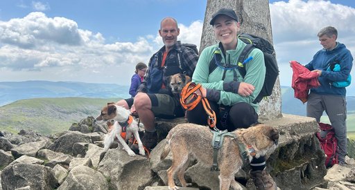 Jess at the top of a mountain with her partner and friends.