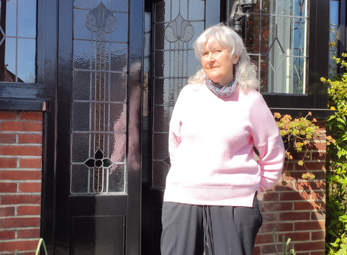 Jill, blood cancer patient, stood outside her house in the sun.