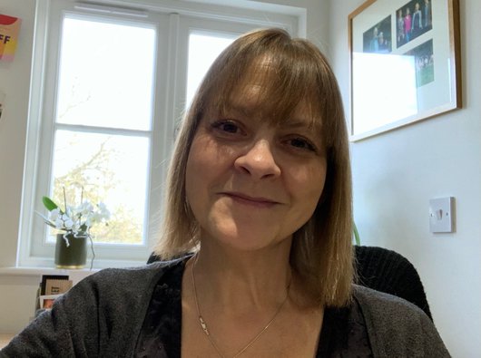 A close up of a selfie Jules Hillier has taken of herself smiling at home by a window.