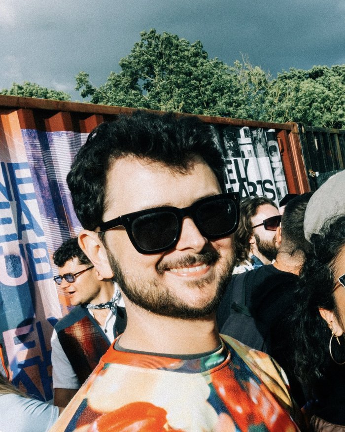 Matt living life in remission from blood cancer. He's smiling and looking happy at an outdoor event, with people in the background.