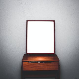 Image of a mirror standing on a dressing table.