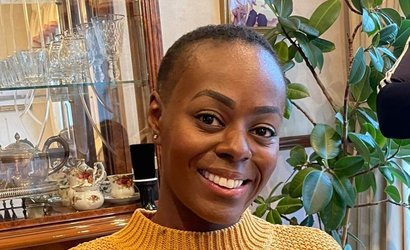 Nadine, wearing a yellow jumper and smiling