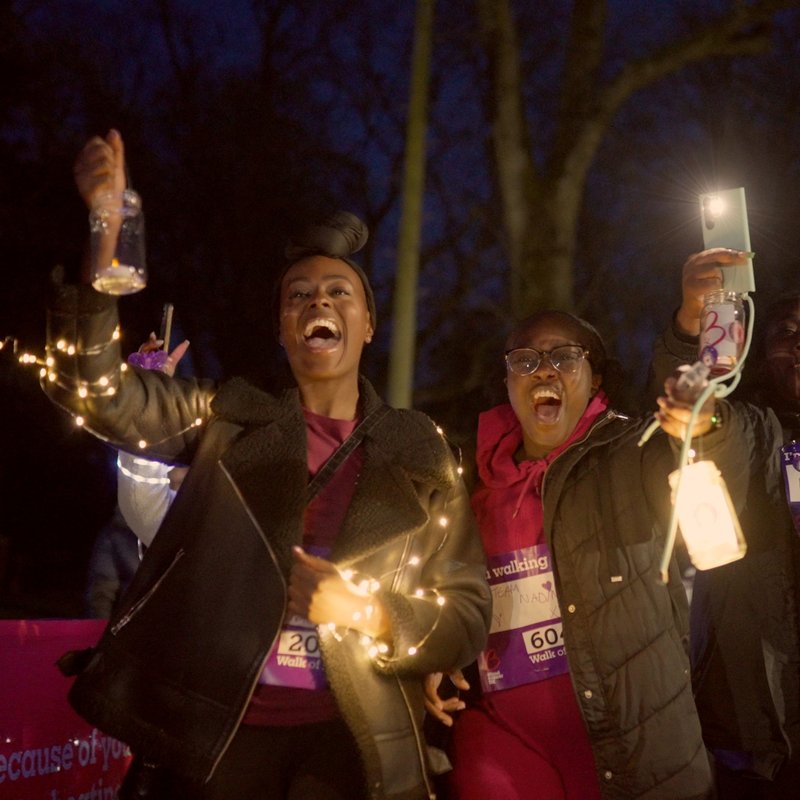 Nadine and friend holding lights up and laughing at Walk of Light Birmingham 2024