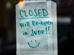 A sign taped to a window announcing a shop is shut and will re-open in June