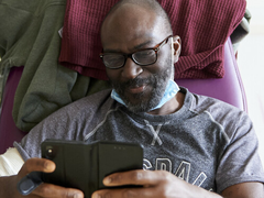 A man in a hospital chair is using his phone