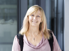 Headshot of a lady with light coloured hair smiling to camera