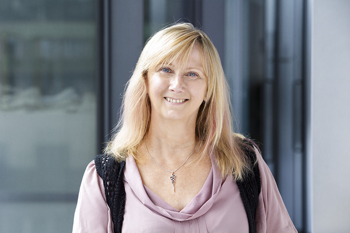 Headshot of a lady with light coloured hair smiling to camera