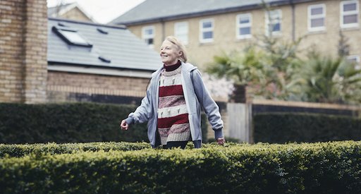 Erica, who has chronic lymphocytic leukaemia (CLL) walking down a path between two bushes.