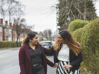 Two friends greeting each other in the street.