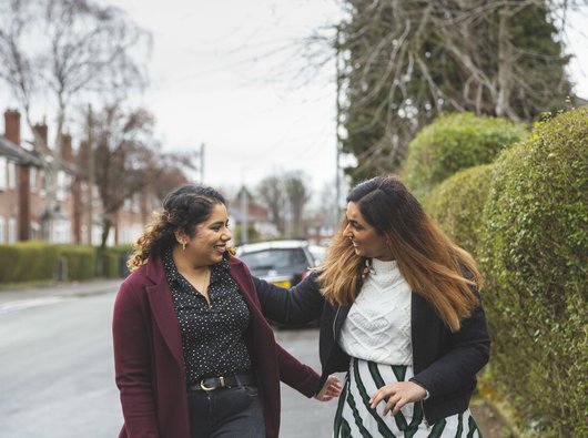 Two friends greeting each other in the street.