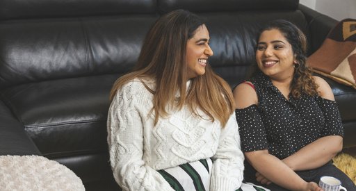 Two friends talking and having a hot drink together.