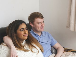 Two friends sitting together with arms round each other.