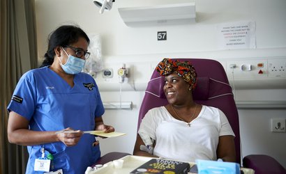 A patient smiles at a health care professional in a hospital room