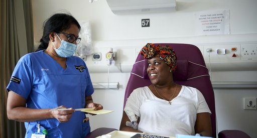 A patient smiles at a health care professional in a hospital room