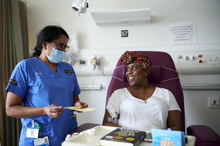 A patient smiles at a health care professional in a hospital room
