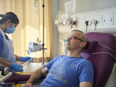 A healthcare professional giving treatment to a man in hospital.