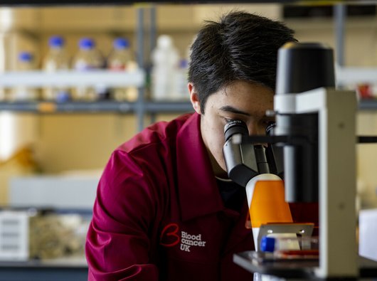 A researcher looking through a microscope.
