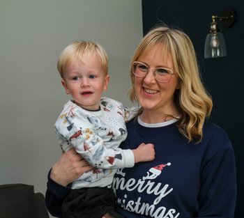 Emma holds her baby son Tobias, they're both smiling and happy