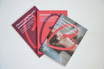 Three health information booklets about blood cancer laid upright.
