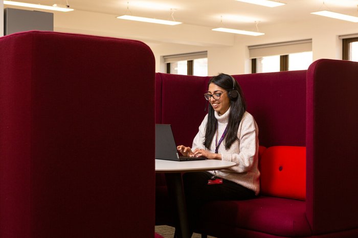 Tanya, a support worker, taking a call on the helpline in a private booth.