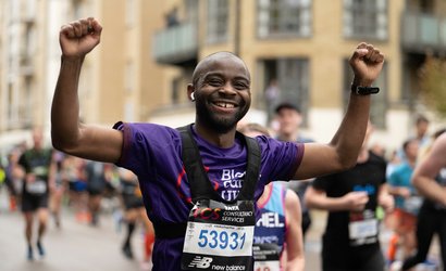 Blood Cancer UK runner, smiling with arms in the air.