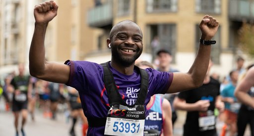 Blood Cancer UK runner, smiling with arms in the air.