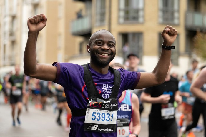 Blood Cancer UK runner, smiling with arms in the air.
