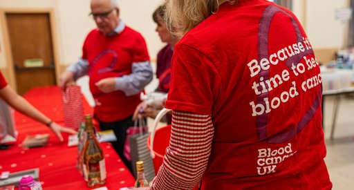 A woman with her back to the camera, showing off her red Blood Cancer UK t-shirt.