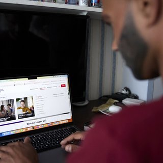 An Asian man looking at blood cancer information on the Blood Cancer UK website.